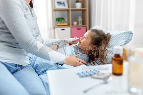 Image of mother with nasal spray treats sick daughter