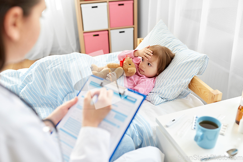 Image of doctor with clipboard and sick girl in bed at home