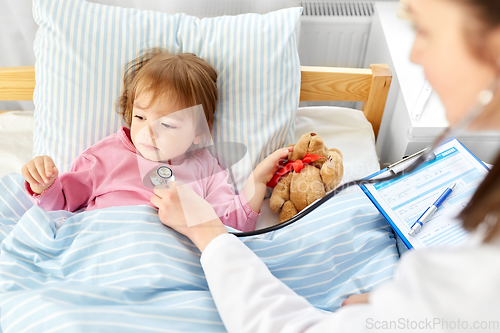 Image of doctor with stethoscope and sick girl in bed