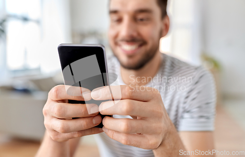 Image of close up of happy man with smartphone at home