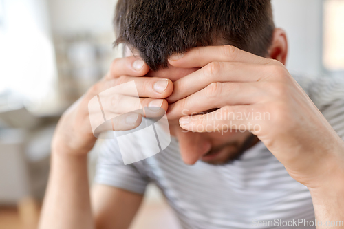 Image of close up of stressed man having headache at home