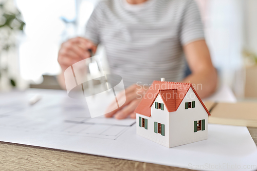 Image of architect with blueprint working at home office