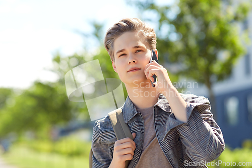 Image of teenage student boy calling on smartphone in city