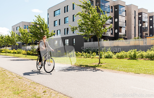 Image of young man riding bicycle on city street