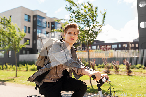 Image of young man riding bicycle on city street