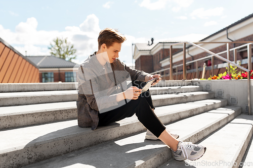 Image of young manor teenage boy with tablet pc in city