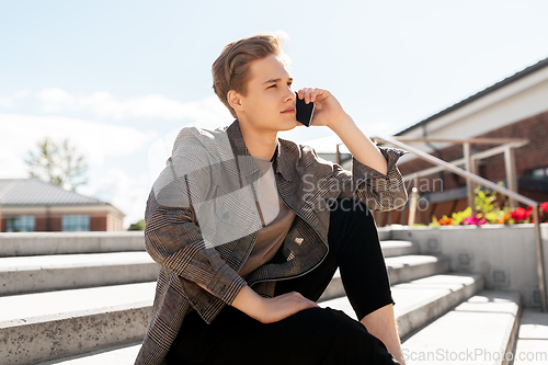 Image of teenage boy calling on smartphone in city