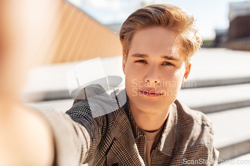 Image of young man or teenage boy taking selfie in city