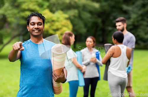 Image of happy man with yoga mat pointing finger to camera