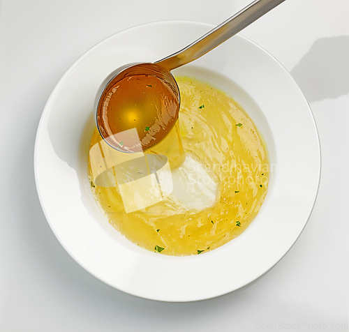 Image of chicken broth pouring into soup plate