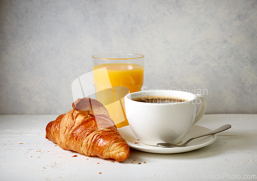 Image of freshly baked croissant and cup of coffee