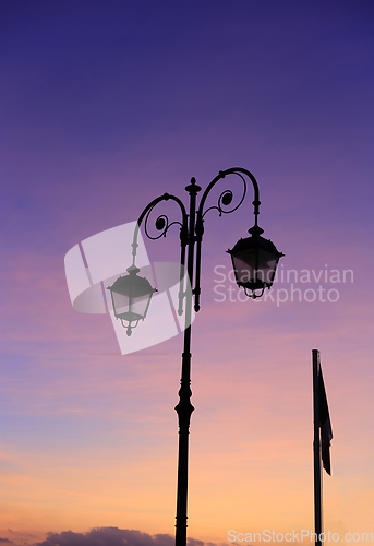 Image of Beautiful vintage street lamp against a bright sunrise sky