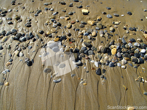 Image of Wet sea pebbles on the sand