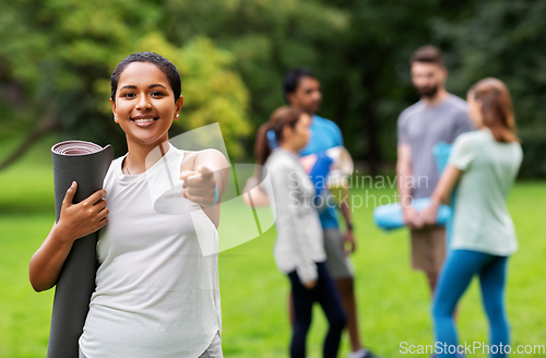 Image of woman with yoga mat pointing finger to camera