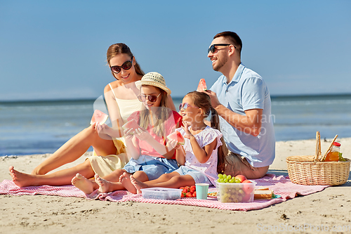 Image of happy family having picnic on summer beach