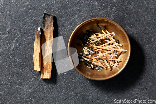 Image of palo santo sticks and cup with burnt matches