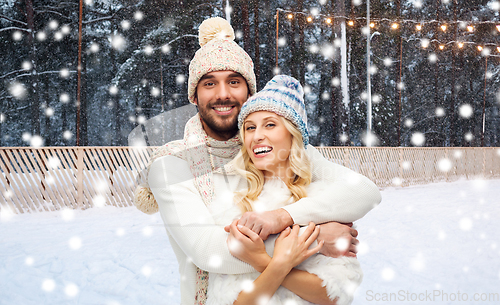 Image of couple hugging over ice skating rink in winter