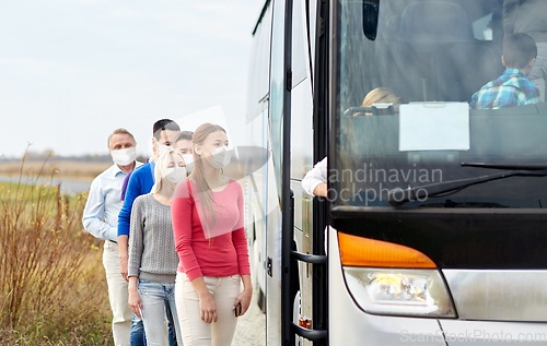 Image of group of passengers in masks boarding travel bus