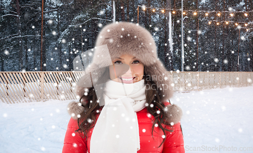 Image of happy woman in winter hat over ice skating rink