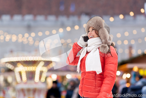 Image of woman calling on smartphone over christmas market