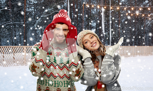 Image of couple in ugly sweaters on christmas ice rink