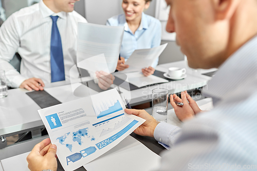 Image of happy business team with papers meeting at office