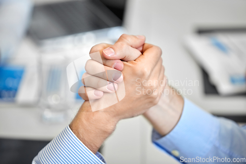 Image of close up of hand arm wrestling at office