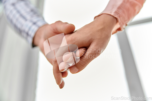 Image of close up of happy couple holding hands at home