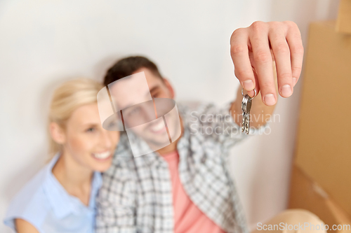 Image of happy couple with key and boxes moving to new home