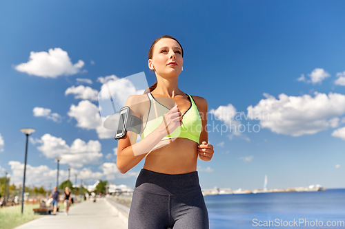 Image of woman with earphones and smartphone running