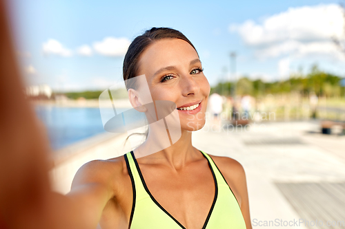 Image of smiling young sporty woman taking selfie picture