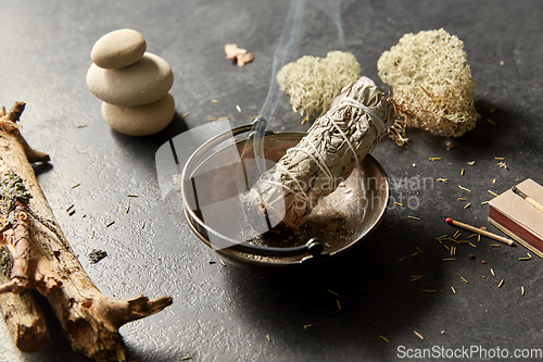 Image of smoking white sage in cup and other magic staff