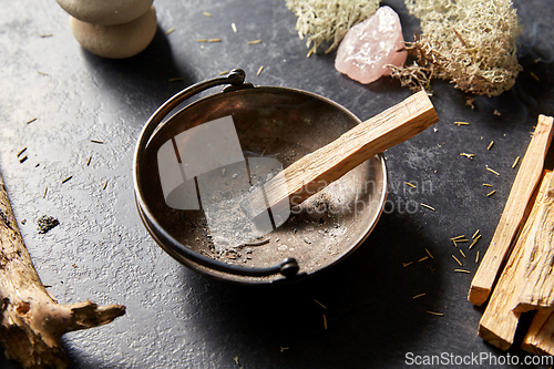Image of palo santo stick in cup and staff for magic ritual