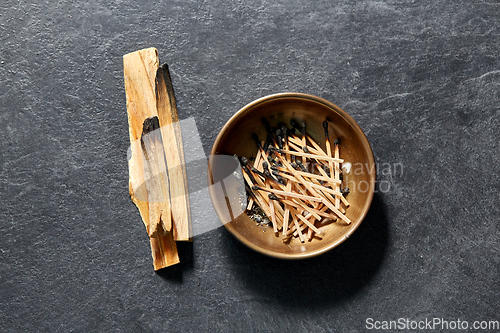 Image of palo santo sticks and cup with burnt matches