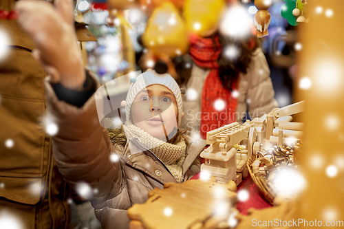 Image of happy family buying souvenirs at christmas market