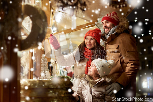 Image of happy family at christmas market in city