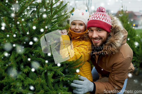 Image of happy family choosing christmas tree at market