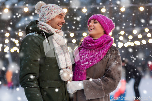 Image of happy couple at outdoor skating rink in winter