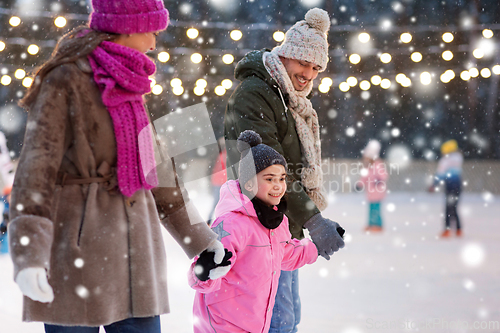 Image of happy family at outdoor skating rink in winter