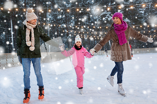 Image of happy family at outdoor skating rink in winter