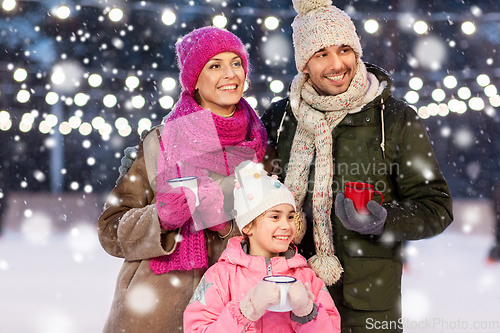 Image of happy family drinking hot tea on skating rink