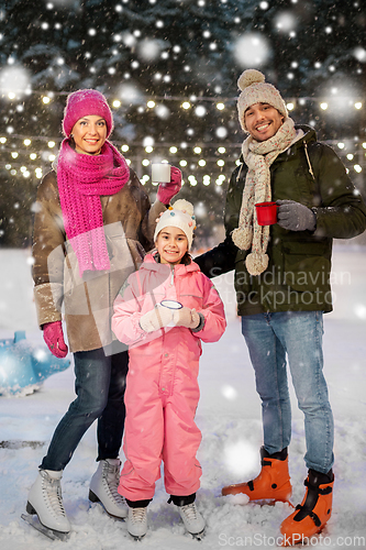 Image of happy family drinking hot tea on skating rink