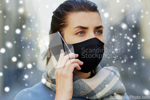 Image of woman in protective reusable mask calling on phone