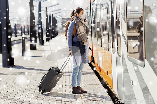 Image of woman in protective face mask at railway station