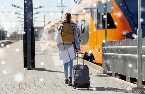 Image of woman with travel bag on railway station