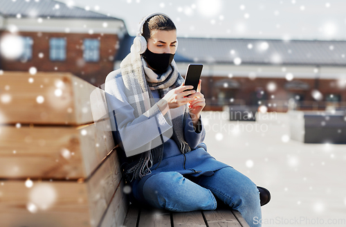 Image of woman in face mask with smartphone in city