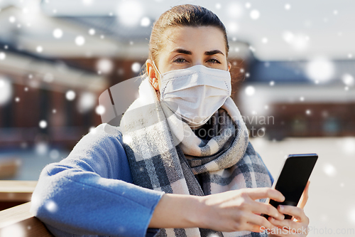 Image of woman in face mask with smartphone in city