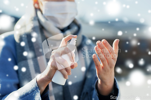 Image of close up of woman spraying hand sanitizer