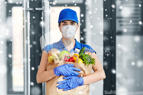 Image of delivery woman in face mask with food in paper bag