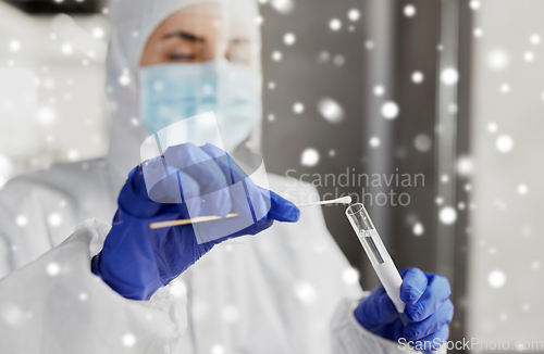 Image of scientist holding beaker with coronavirus test